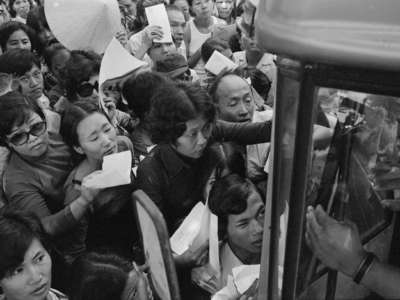 Waving their credentials, a crowd of South Vietnamese citizens gathered around a U.S. Embassy bus on April 24, 1975, during the fall of Saigon.