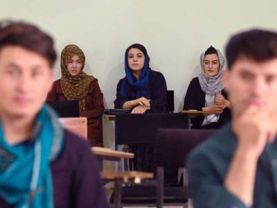 Women in Hijab sit at the back of a classroom