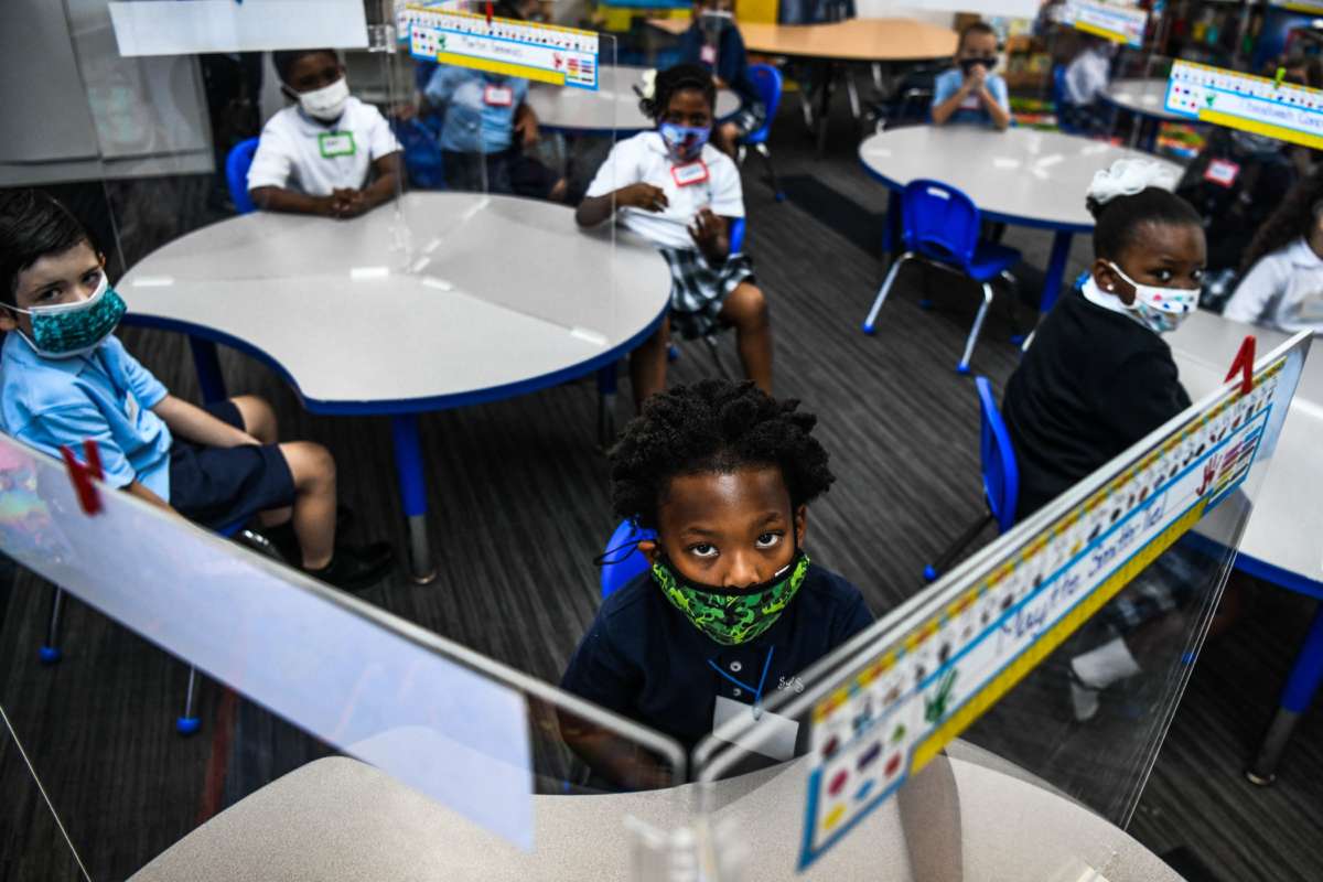 A bunch of school children glare daggers into whatever poor getty photographer is in their classroom