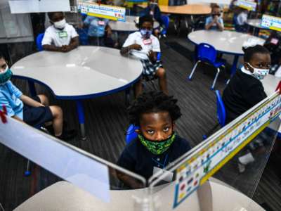 A bunch of school children glare daggers into whatever poor getty photographer is in their classroom