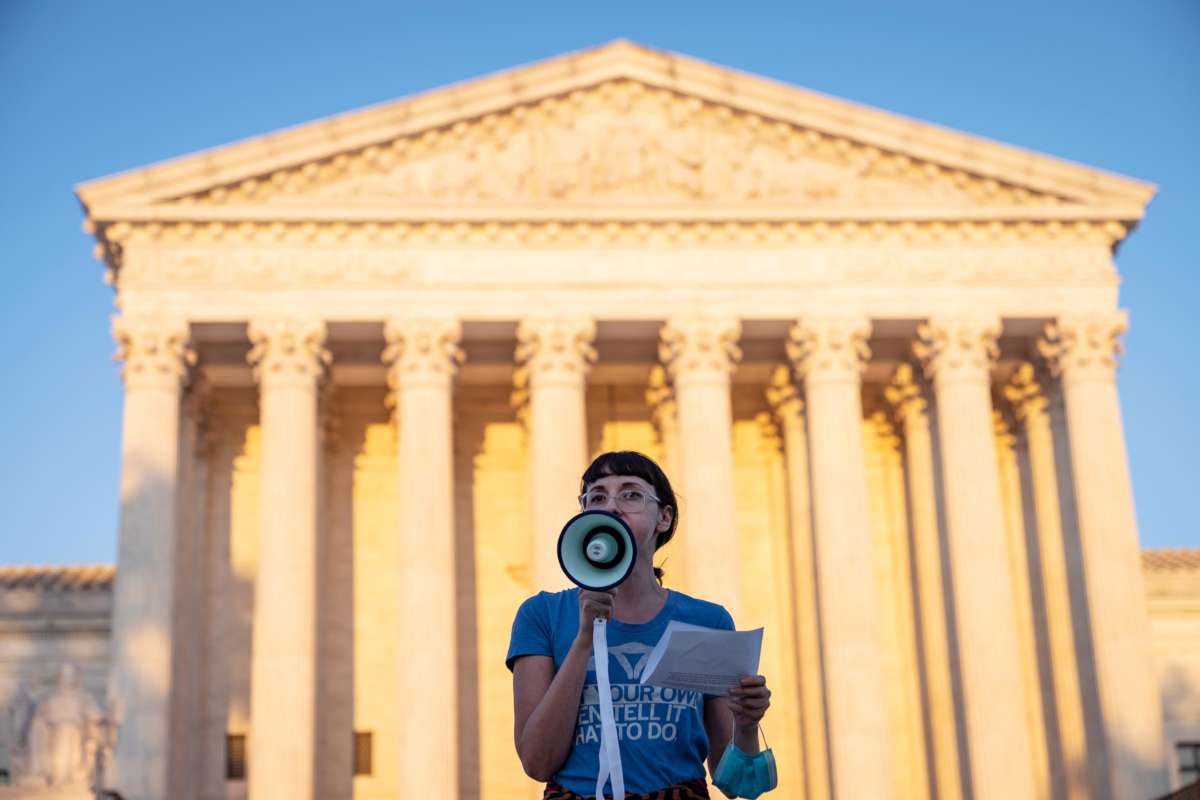 An activist speaks into a megaphone on the steps of the Supreme Court of the United States