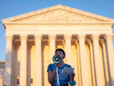 An activist speaks into a megaphone on the steps of the Supreme Court of the United States