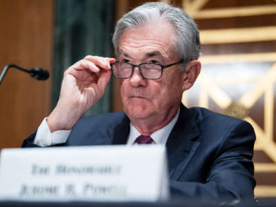 Jerome Powell looks over his glases