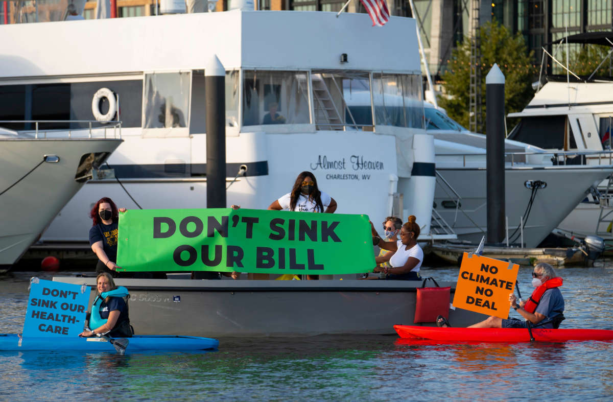 A flotilla of activists from Center for Popular Democracy, Court Appointed Special Advocates and Greenpeace USA take to kayaks and electric boats to demonstrate near Sen. Joe Manchin’s houseboat in Washington, D.C. to demand that he support the Build Back Better Act, on September 27, 2021.