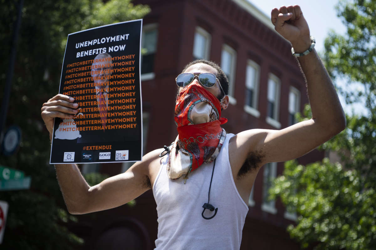 A demonstrator rallies near the Capitol Hill residence of then-Senate Majority Leader Mitch McConnell to call for an extension of unemployment benefits on July 22, 2020.