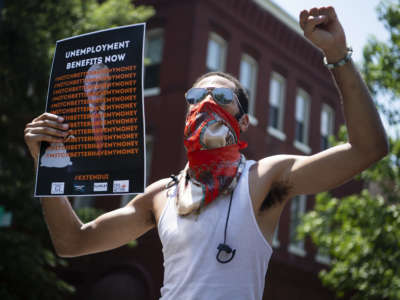 A demonstrator rallies near the Capitol Hill residence of then-Senate Majority Leader Mitch McConnell to call for an extension of unemployment benefits on July 22, 2020.