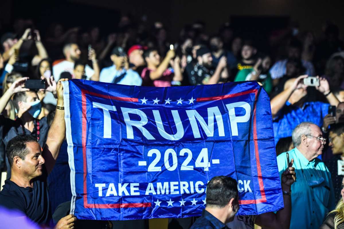 Supporters of former President Donald Trump hold a flag as he hosts the Holyfield vs. Belford boxing match live with commentary at the Hard Rock Live in Hollywood, Florida on September 11, 2021.