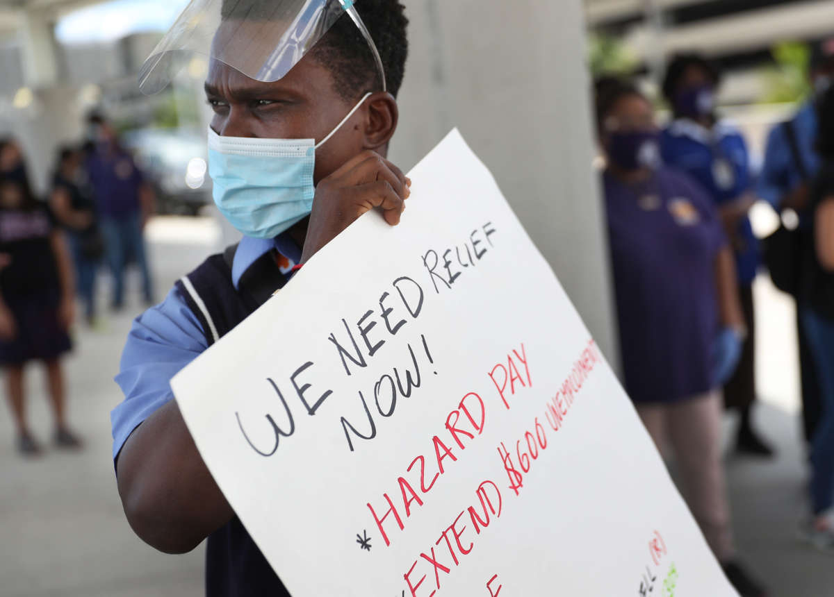 Jean Benjamin joins with unemployed airport workers, the Black Lives Matter Alliance of Broward and other supporters to ask that Delta Airlines contractor, Eulen America, who the demonstrators say received $25 million from the CARES Act, hire back their unemployed Fort Lauderdale-Hollywood International Airport workers on August 13, 2020, in Fort Lauderdale, Florida.