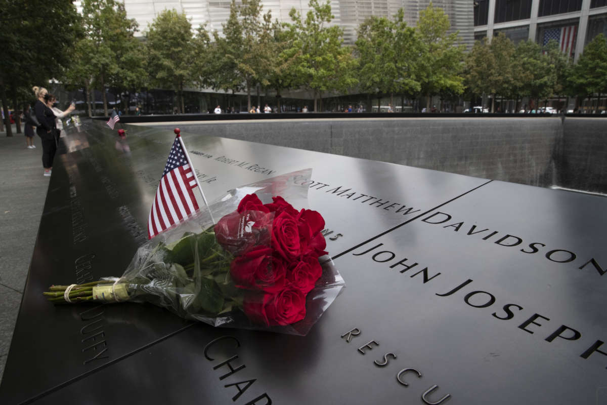 A U.S. flag and a flower are placed near a victim's name at the National September 11 Memorial & Museum at Ground Zero on September 8, 2021, in New York.