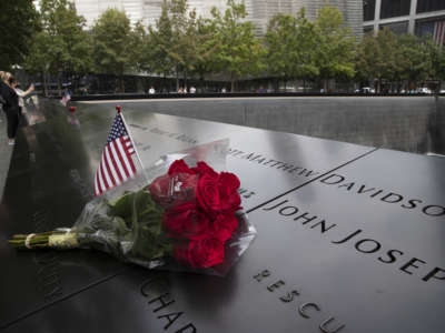 A U.S. flag and a flower are placed near a victim's name at the National September 11 Memorial & Museum at Ground Zero on September 8, 2021, in New York.