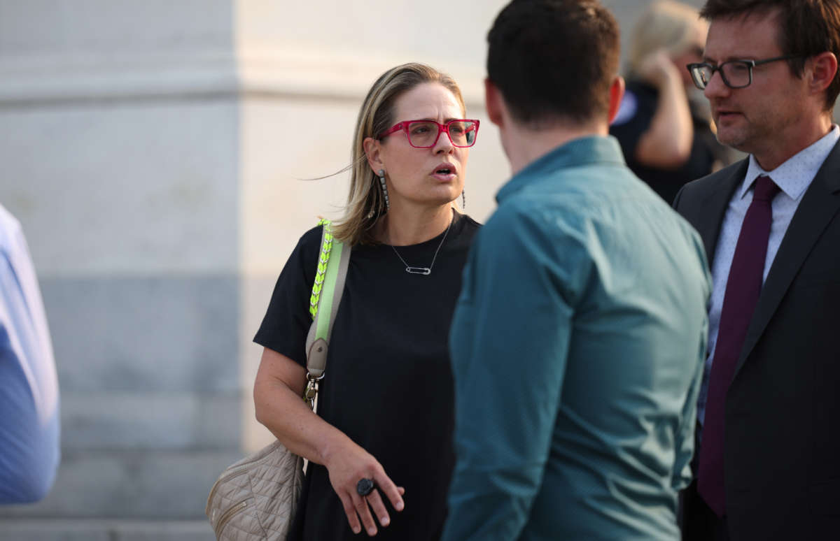 Sen. Kyrsten Sinema speaks with members of her staff as she departs from the U.S. Capitol Building on July 19, 2021, in Washington, D.C.