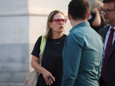 Sen. Kyrsten Sinema speaks with members of her staff as she departs from the U.S. Capitol Building on July 19, 2021, in Washington, D.C.
