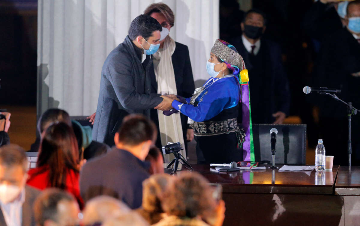 Constitutional lawyer Jaime Bassa, left, elected vice president of the Constitutional Convention, is greeted by elected President Elisa Loncón at the National Congress during the First Constituent Assembly in Santiago, Chile, on July 4, 2021.