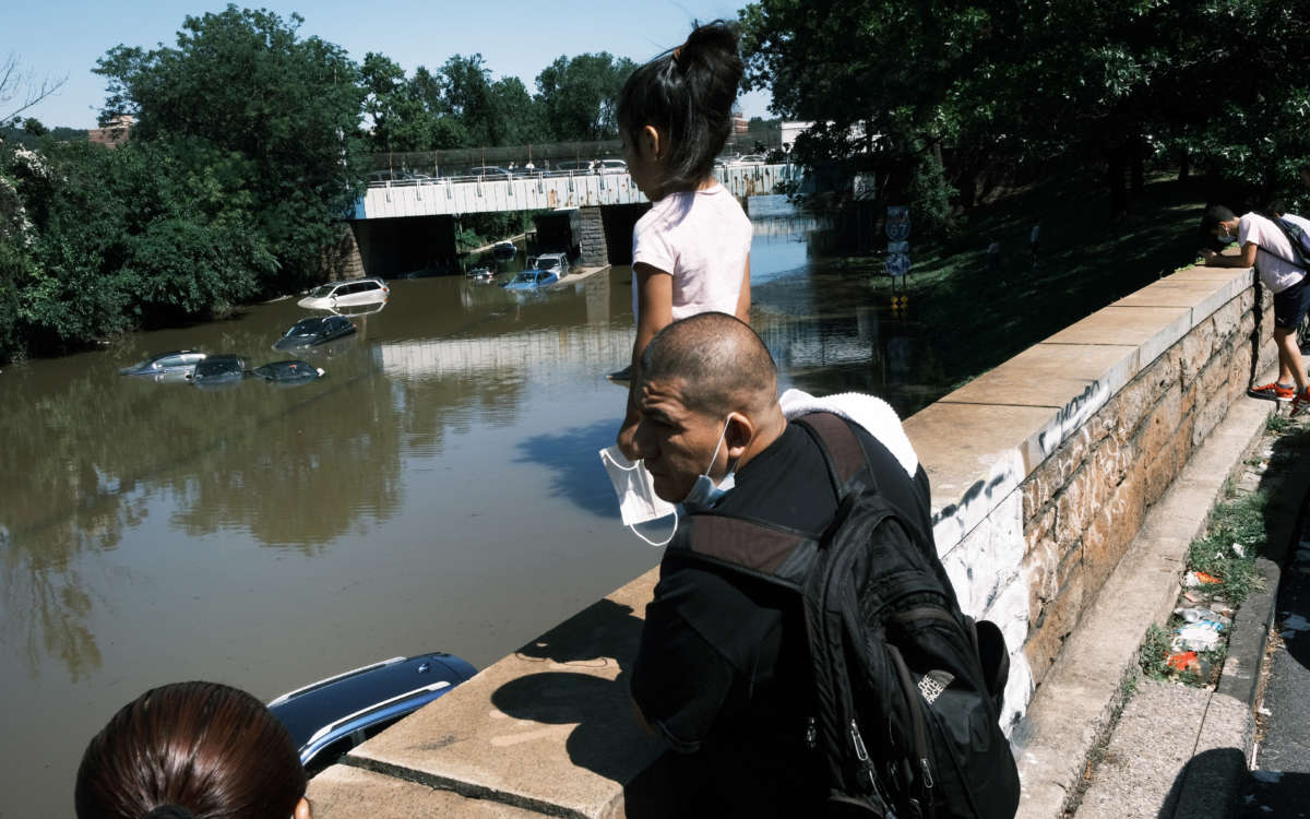 People look at cars abandoned on the flooded Major Deegan Expressway following a night of extremely heavy rain from the remnants of Hurricane Ida on September 2, 2021, in the Bronx borough of New York City.