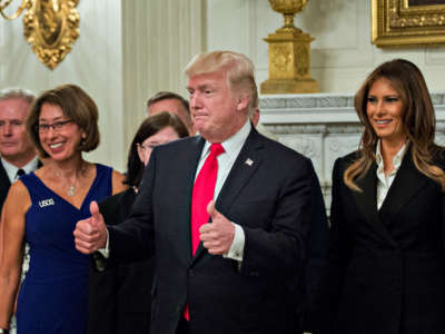 President Donald Trump and first lady Melania Trump pose for pictures with senior military leaders and spouses after a briefing in the State Dining Room of the White House on October 5, 2017, in Washington, D.C.