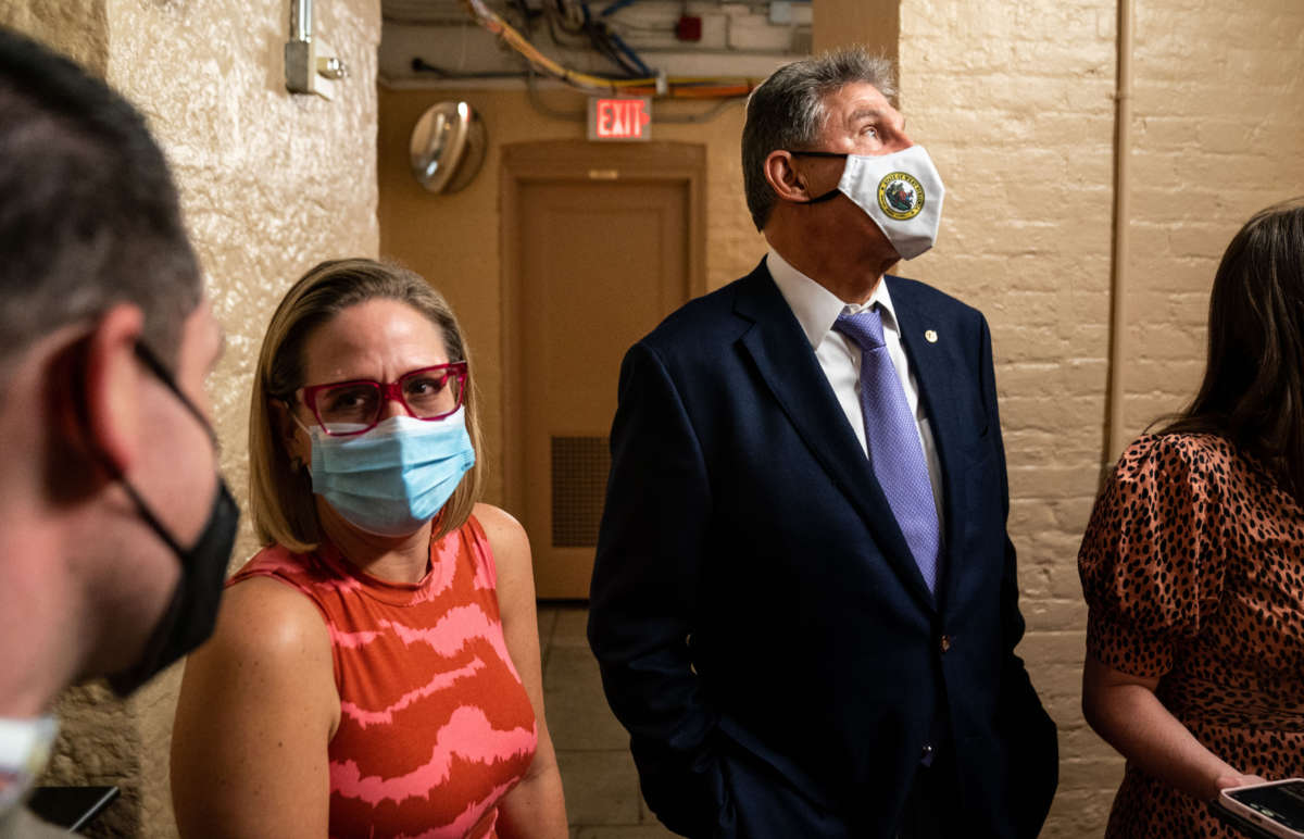 Sen. Kyrsten Sinema and Sen. Joe Manchin wait for an elevator in the U.S. Capitol on September 30, 2021, in Washington, D.C.