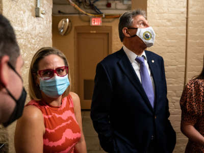 Sen. Kyrsten Sinema and Sen. Joe Manchin wait for an elevator in the U.S. Capitol on September 30, 2021, in Washington, D.C.