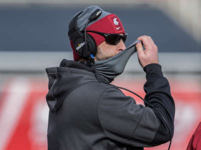 Nick Rolovich head coach of the Washington State Cougars adjusts his mask during their game against the Utah Utes on December 19, 2020, at Rice Eccles Stadium in Salt Lake City, Utah.
