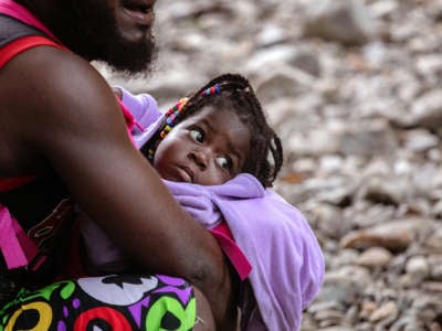 A Haitian baby is held by her dad