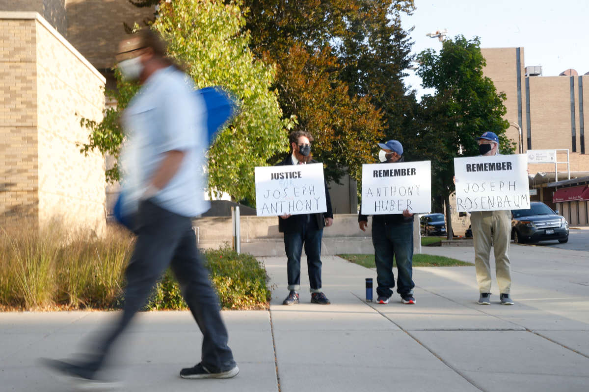 Protesters hold signs outside the Lake County Courthouse in Waukegan, Illinois, to remember victims of alleged Kenosha shooter Kyle Rittenhouse, on September 25, 2020.