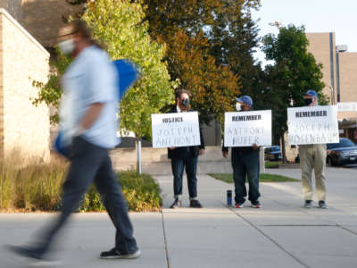 Protesters hold signs outside the Lake County Courthouse in Waukegan, Illinois, to remember victims of alleged Kenosha shooter Kyle Rittenhouse, on September 25, 2020.