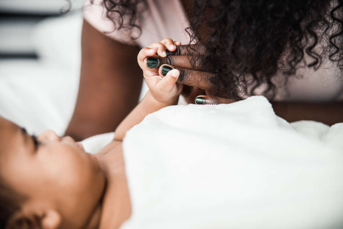 Close-up of baby hand holding mommy's fingers.