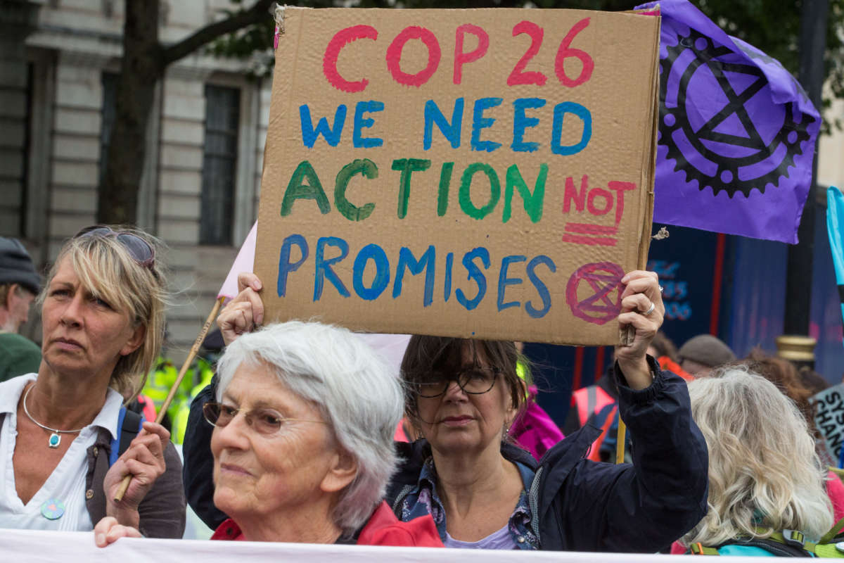 An environmental activist from Extinction Rebellion holds a sign calling for action at COP26 during the first day of Impossible Rebellion protests on August 23, 2021, in London, United Kingdom.