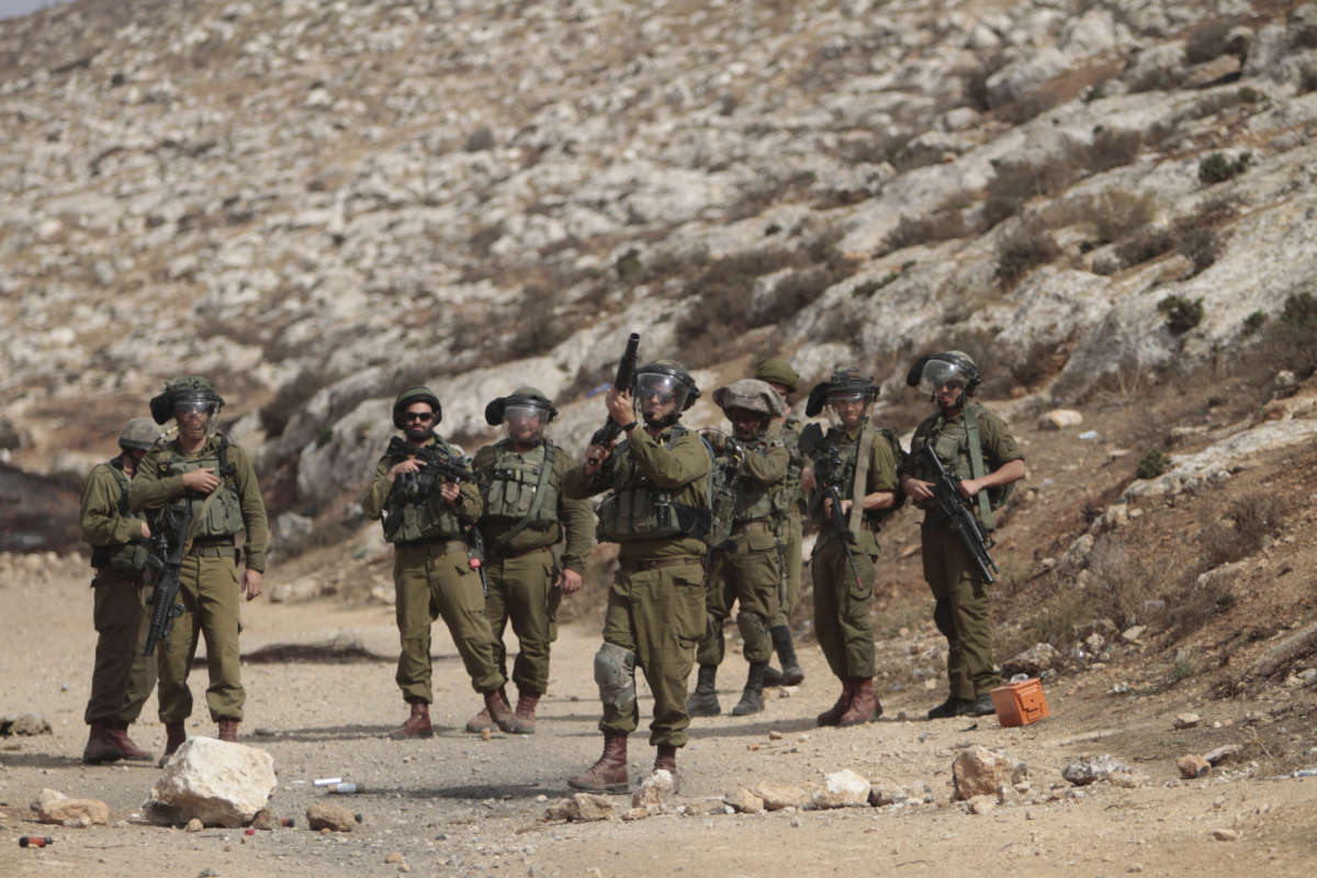 An Israeli soldier is seen aiming at Palestinian protesters, during a demonstration against Israeli settlements in the village of Beit Dajan near the West Bank city of Nablus on October 29, 2021.