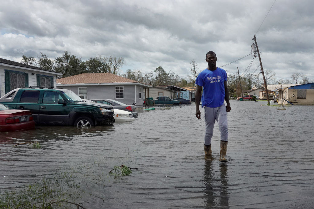 A resident of Laplace, Louisiana, wades through floodwaters after Hurricane Ida made landfall August 29, 2021, as a category 4 storm southwest of New Orleans. Water has always shaped life in Louisiana, where people are already preparing for intensifying storms and demanding the next generation of climate resilient green infrastructure.