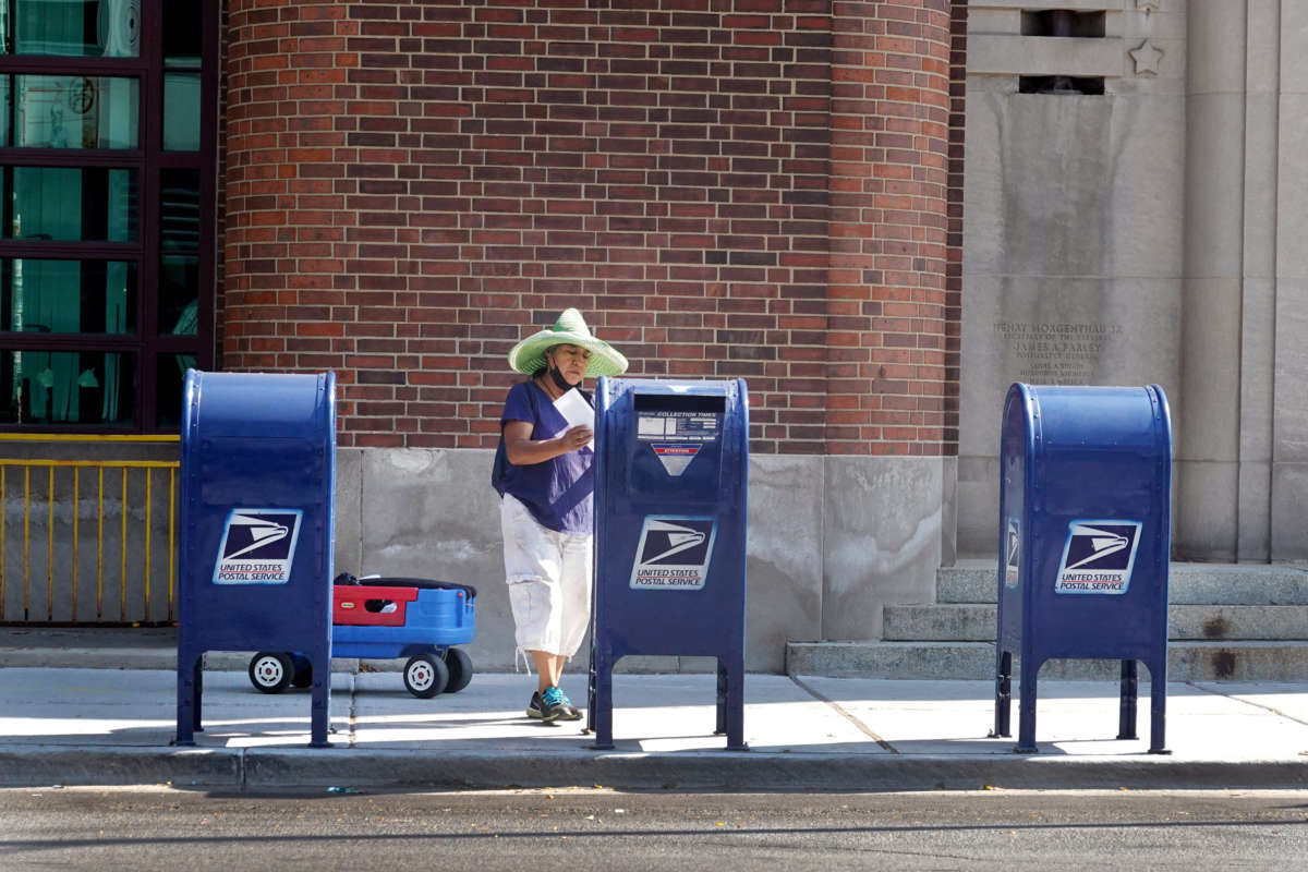 A postal service costumer mails a letter on October 1, 2021, in Chicago, Illinois.