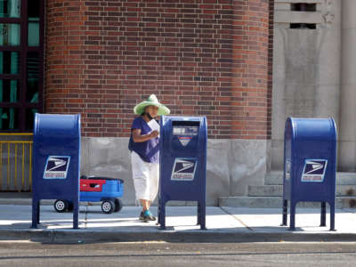 A postal service costumer mails a letter on October 1, 2021, in Chicago, Illinois.