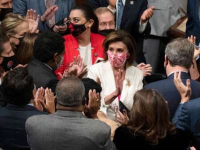 Members applaud Speaker of the House Nancy Pelosi (C) (D-California) and chant her name after she announced the passage of the Build Back Better Act on the floor of the House on Capitol Hill in Washington, D.C., on November 19, 2021.