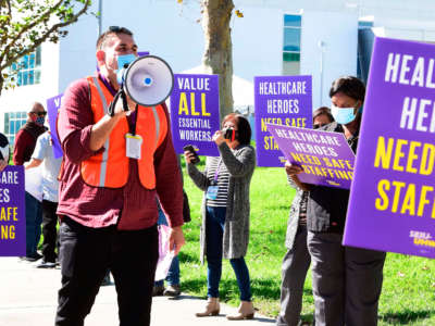 Workers protest Kaiser Permanente's attempt to replace workers who have good environmental services housekeeping jobs with robots, at Baldwin Park Medical Center outside the facility on November 10, 2020, in Baldwin Park, California.
