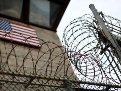 Razor wire tops a fence near the guard tower at the entrance to Camp V and VI at the U.S. military prison for "enemy combatants" on June 25, 2013, in Guantánamo Bay, Cuba.