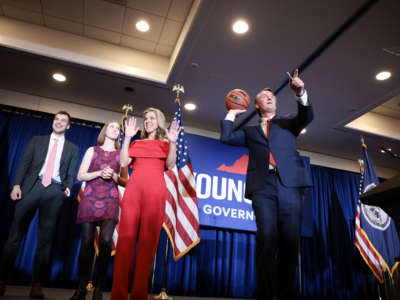 Virginia Republican gubernatorial candidate Glenn Youngkin passes an autographed basketball into the crowd with his family at his election night rally at the Westfields Marriott Washington Dulles on November 2, 2021, in Chantilly, Virginia.