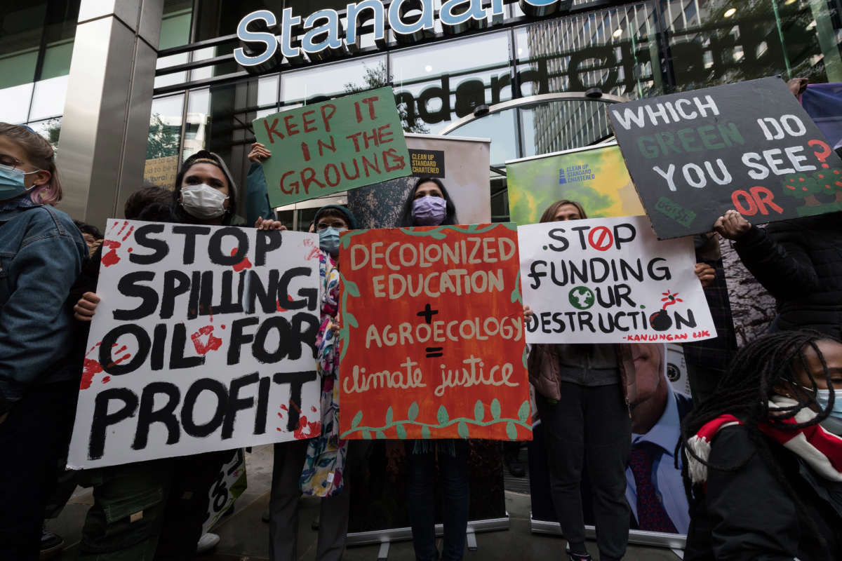 Youth climate activists protest outside the Standard Chartered HQ against financing of fossil fuel projects during the "Defund Climate Chaos" global day of action targeting City of London's banking, insurance and investment companies in London, United Kingdom, on October 29, 2021.