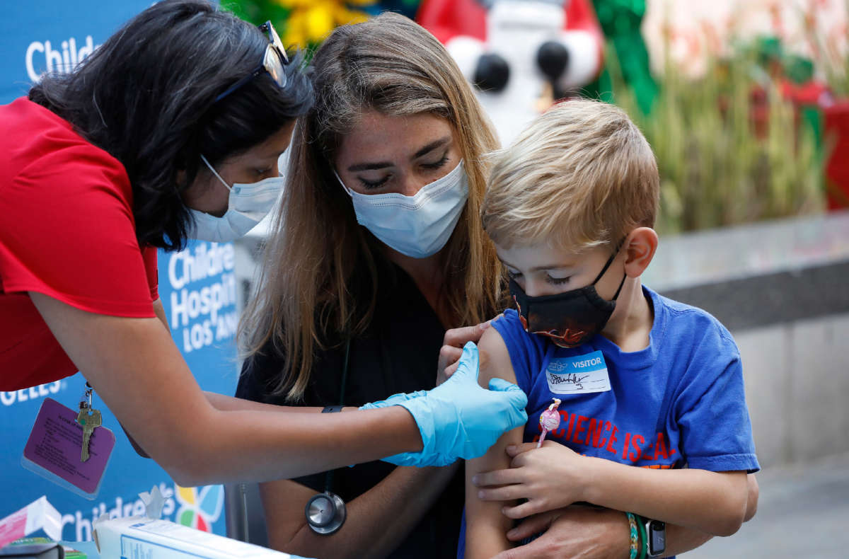 A 6-year-old is held by his mother as a nursing professional development manager administers the children's dose of the Pfizer COVID vaccine at Children's Hospital of Los Angeles on November 3, 2021, in Los Angeles, California.