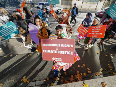 Indigenous people in ceremonial dress march from the McLennan Arch, Glasgow Green Park to the Scottish Event Campus in Glasgow to announce their arrival at the COP26 summit on November 3, 2021.