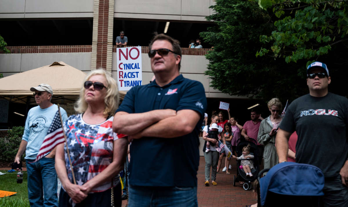 People listen to speakers during a rally against "critical race theory" (CRT) being taught in schools at the Loudoun County Government center in Leesburg, Virginia, on June 12, 2021.