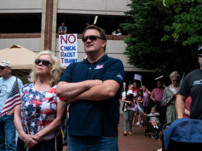 People listen to speakers during a rally against "critical race theory" (CRT) being taught in schools at the Loudoun County Government center in Leesburg, Virginia, on June 12, 2021.