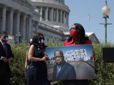 Rep. Terri Sewell holds a photo of the late Rep. John Lewis at a press event outside of the U.S. Capitol on August 24, 2021, in Washington, D.C.