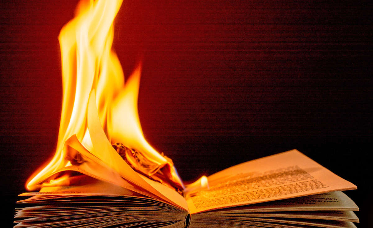 Burning book engulfed in brilliant orange, yellow, and red flames.