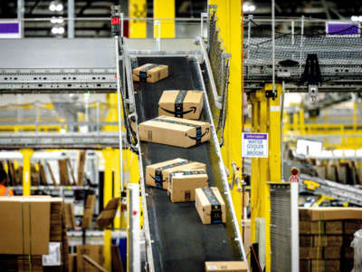 Packages move along a conveyor at Amazon fulfillment center in Eastvale, California, on August 31, 2021.