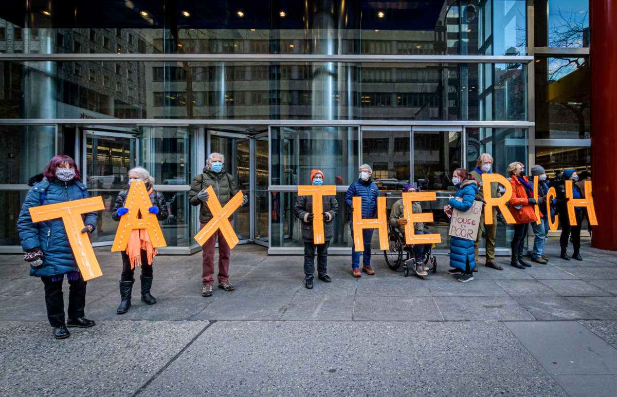 Demonstrators hold letters spelling “TAX THE RICH” outside then-Gov. Andrew Cuomo’s office in Manhattan, New York, on January 5, 2021.
