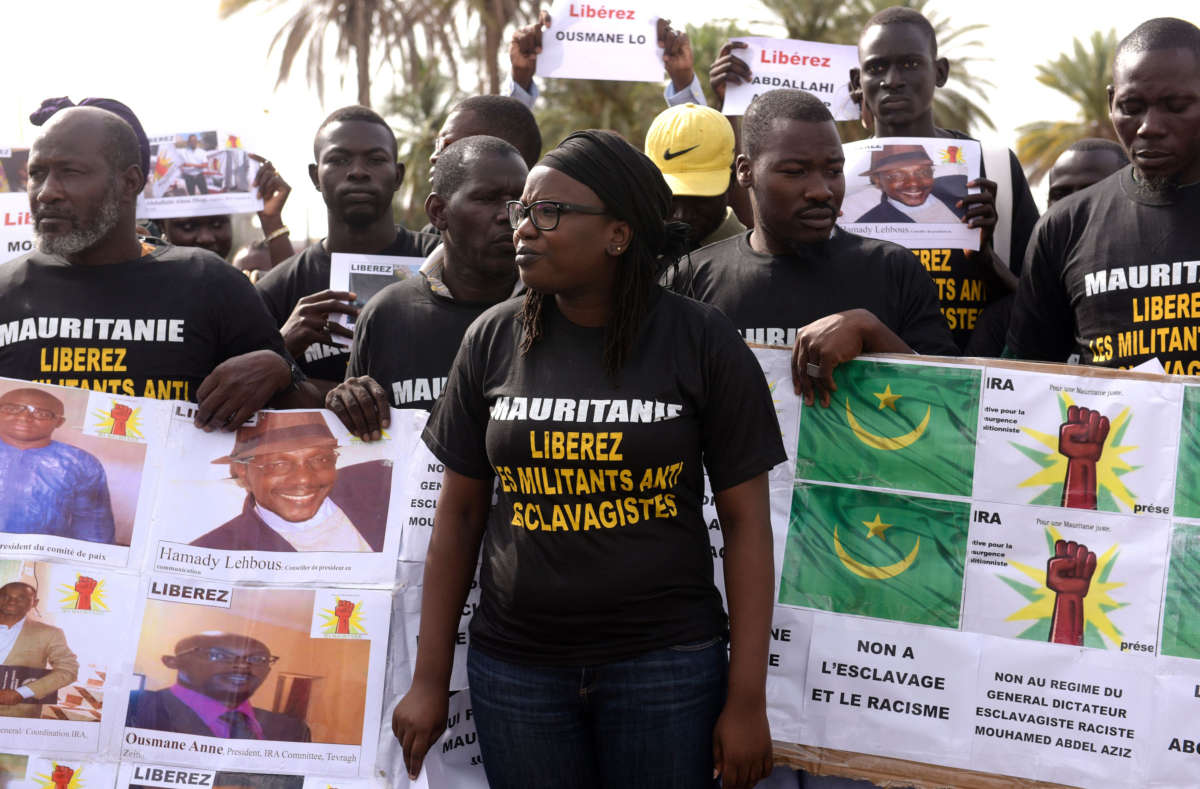 Demonstrators protesting against the imprisonment of anti-slavery activists in Mauritania hold a banner which translates to: “No to slavery and racism” on August 3, 2016, in Dakar, Senegal.