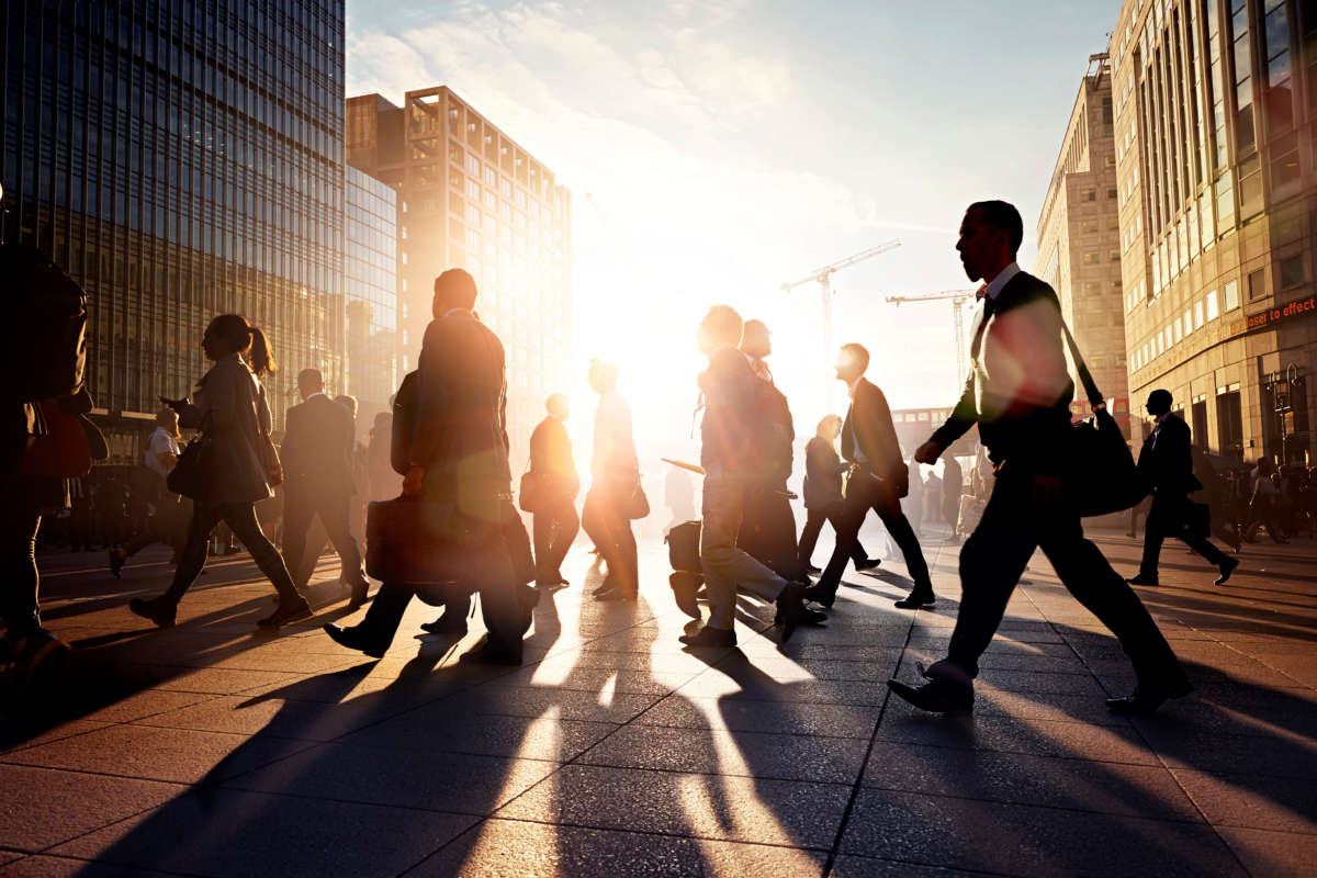 Commuters walking in a city at sunrise