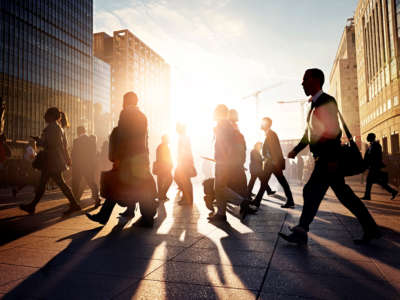Commuters walking in a city at sunrise