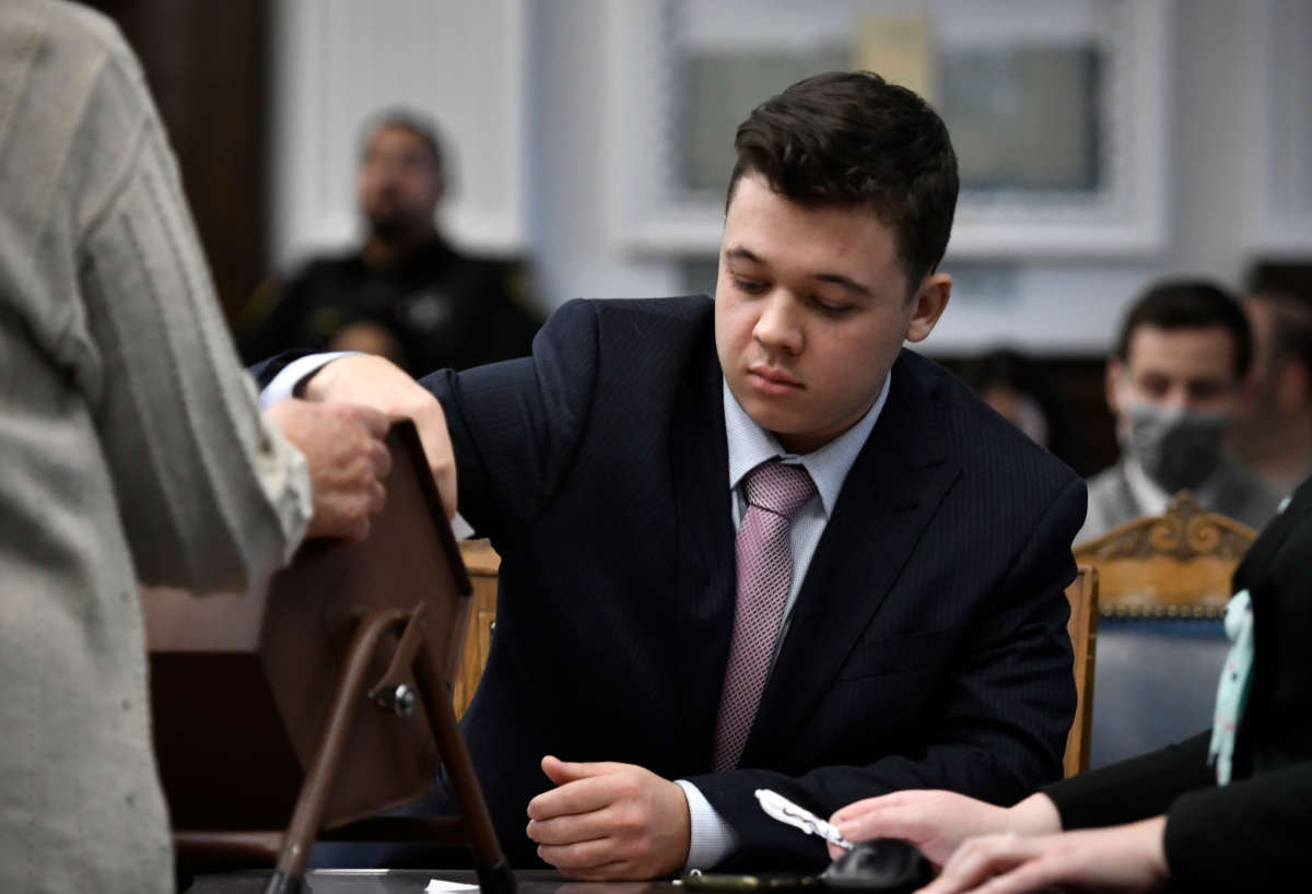 Kyle Rittenhouse pulls numbers of jurors out of a tumbler during his trial at the Kenosha County Courthouse on November 16, 2021, in Kenosha, Wisconsin.