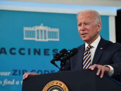 President Joe Biden speaks at podium on vaccines at South Court Auditorium of White House