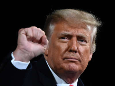 Former President Donald Trump raises his fist at the end of a campaign rally at Valdosta Regional Airport in Valdosta, Georgia on December 5, 2020.